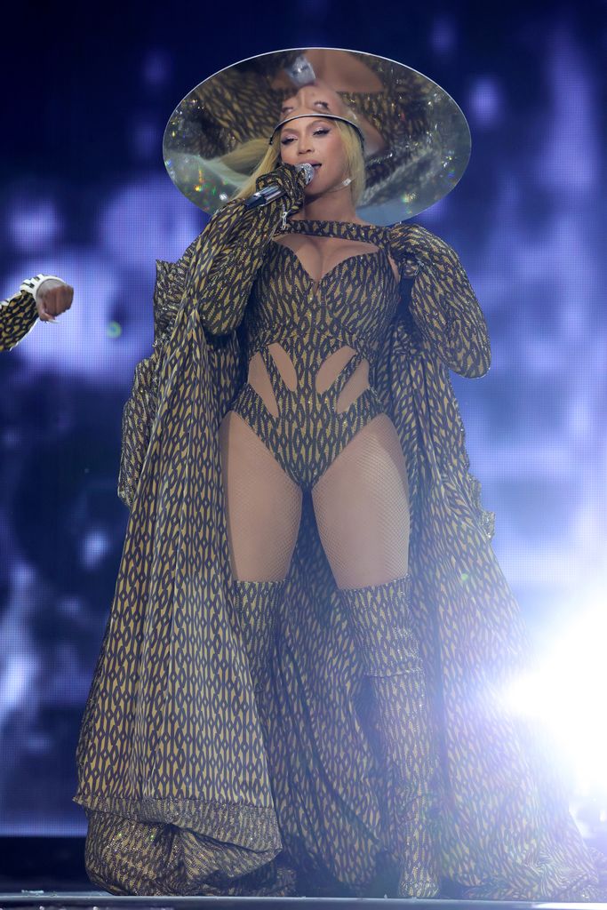 Beyonce  on stage in printed bodysuit, boots and hat