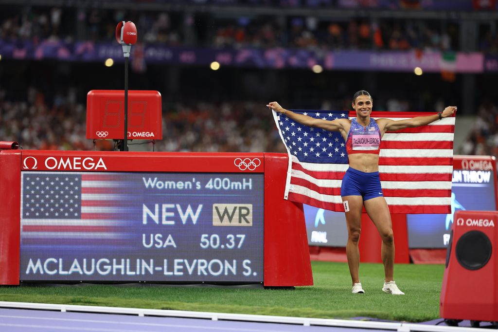 Sydney McLaughlin-Levrone of Team United States poses in front of the scoreboard after winning the gold medal and breaking the World record on day thirteen of the Olympic Games Paris 2024 at Stade de France on August 08, 2024 in Paris, France.