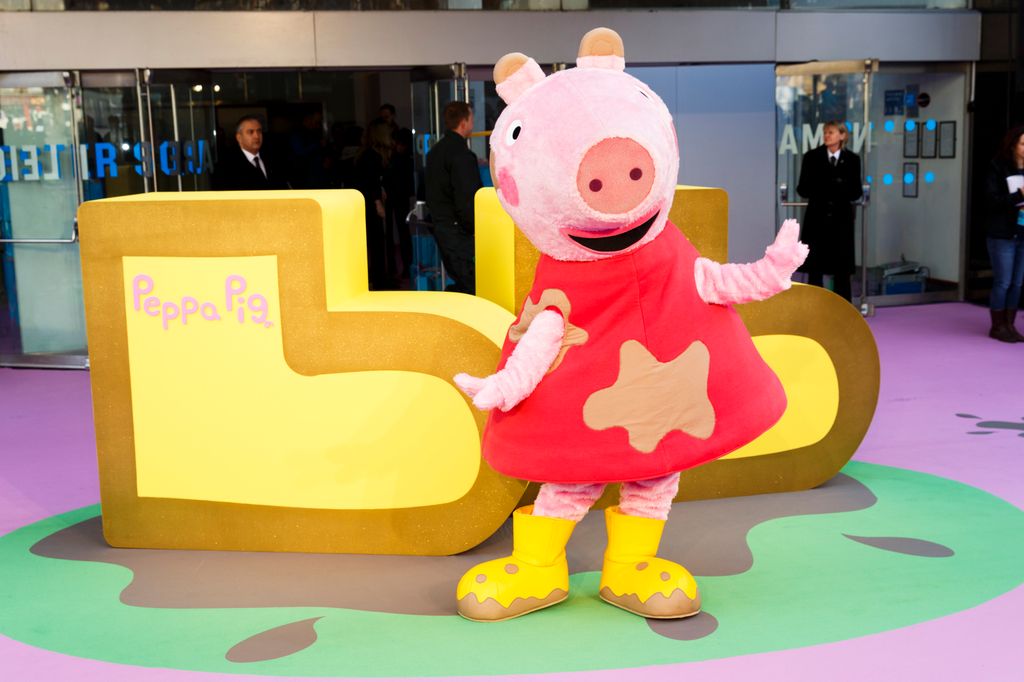 Peppa Pig in a red dress and yelllow boots in front of lit up yellow boots 