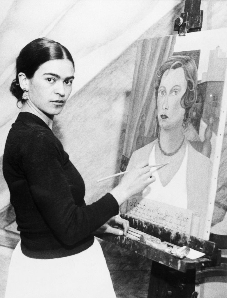 Frida Kahlo, in 1931, with one of her portraits of a San Francisco society woman.