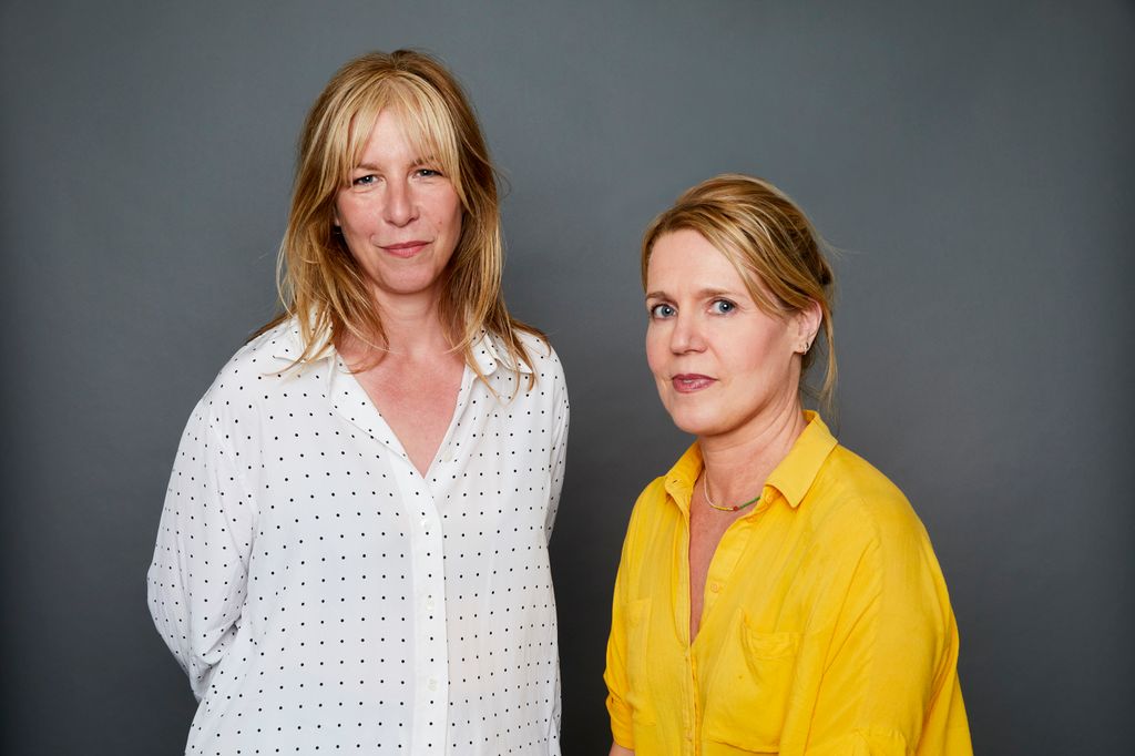 two blonde women sitting for a headshot