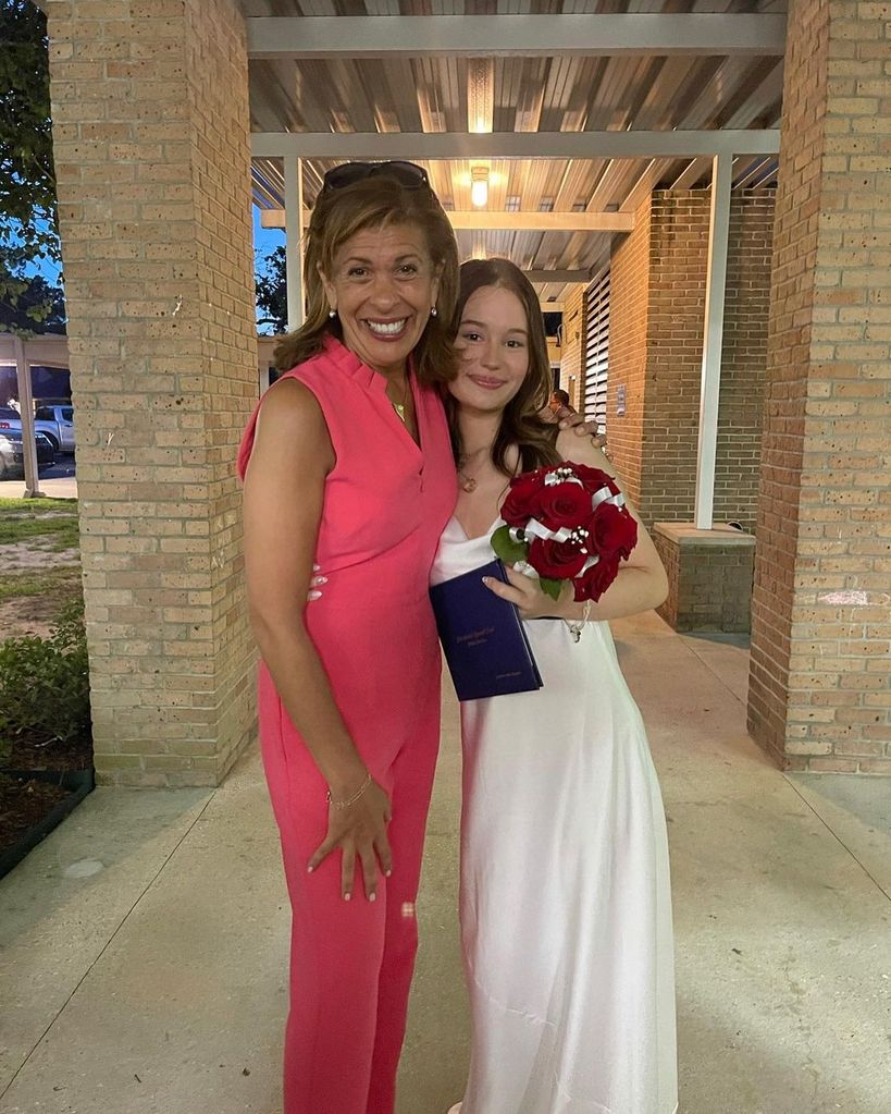 Hoda Kotb wears a pink dress beside family friend Catherine Hope who wears a white dress and holds red roses