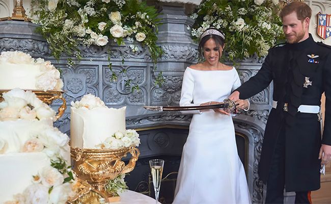 Harry and Meghan cutting wedding cake with ceremonial sword