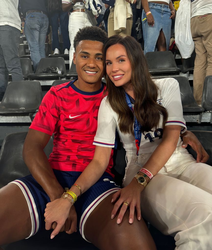 couple smiling in football stands 