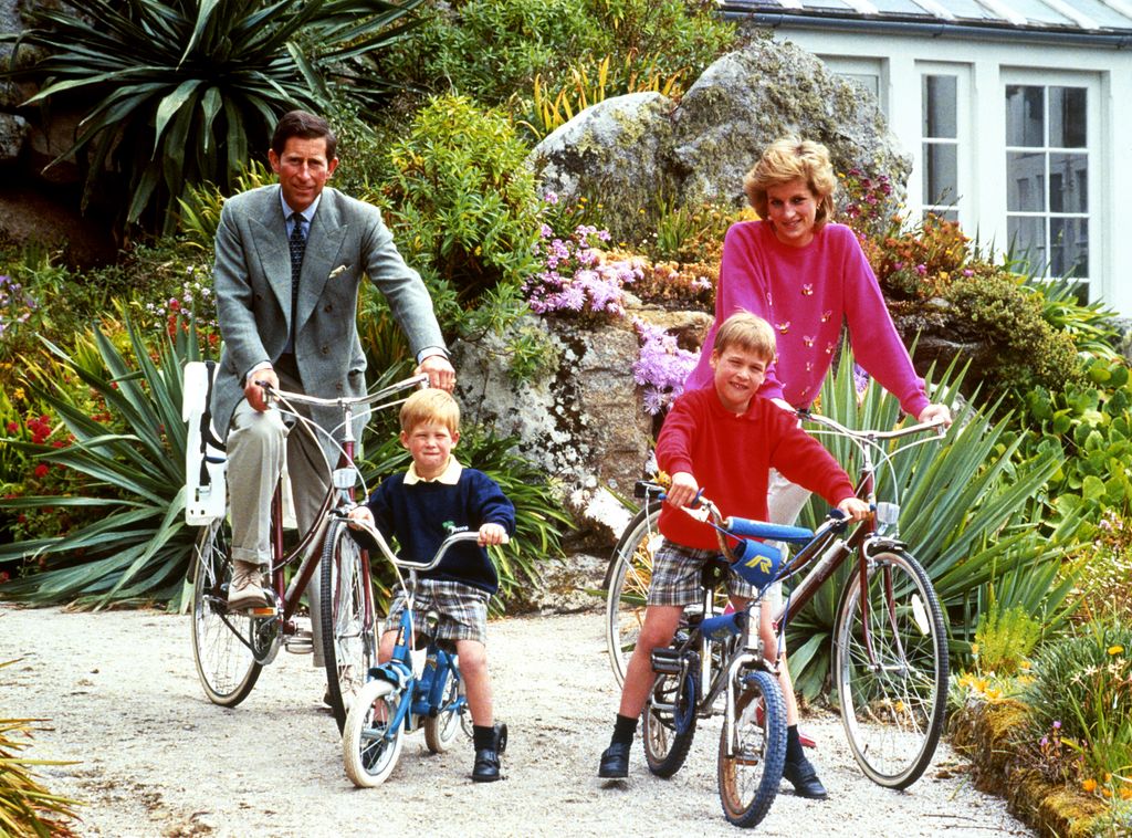 The Prince and Princess of Wales with sons Prince William, right, and Prince Harry during a cycling trip in Tresco during their holiday in the Scilly Isles.