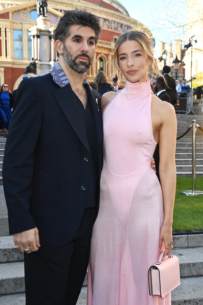 Simon Lipkin posing with Georgina Castle in a pink semi-sheer dress
