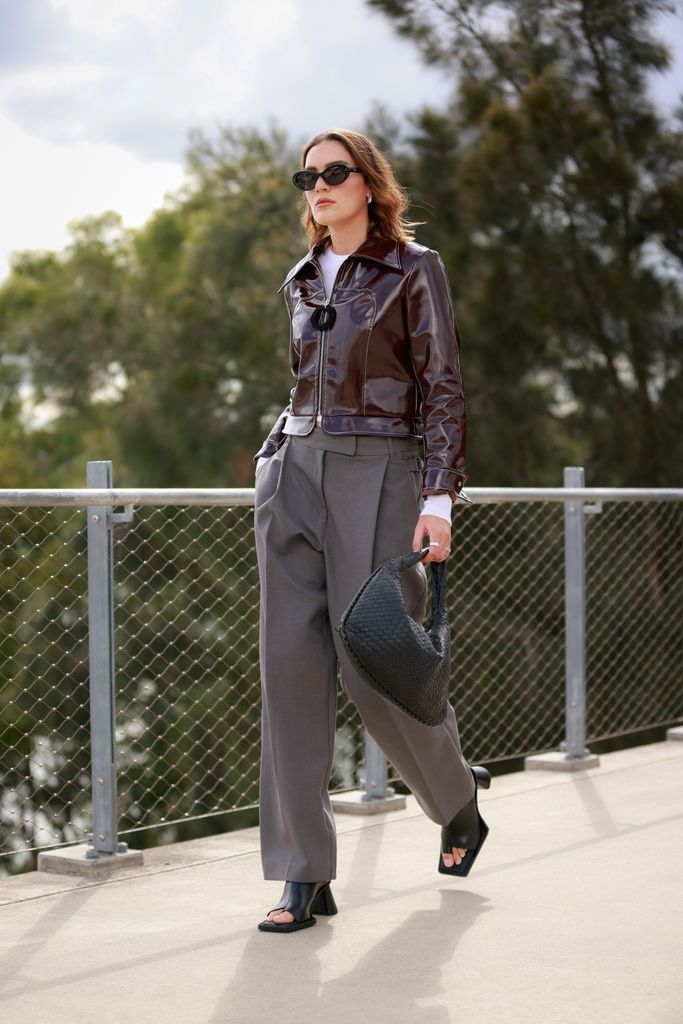 Holly Lyle wears a glossy boxy jacket, tailored trousers and mules 