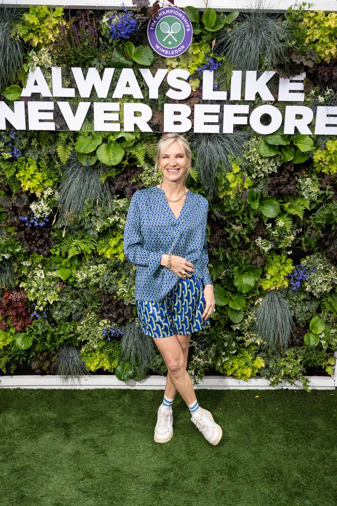 Jo Whiley posed with leafy backdrop in printed shirt and shorts