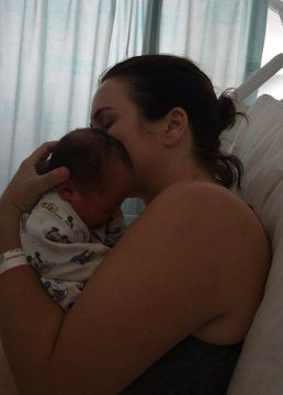 Nina Warhurst cradling newborn baby in hospital bed