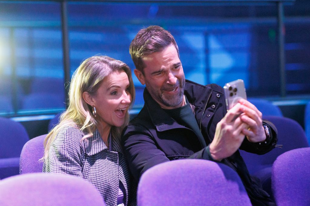man and woman taking selfie in purple chairs