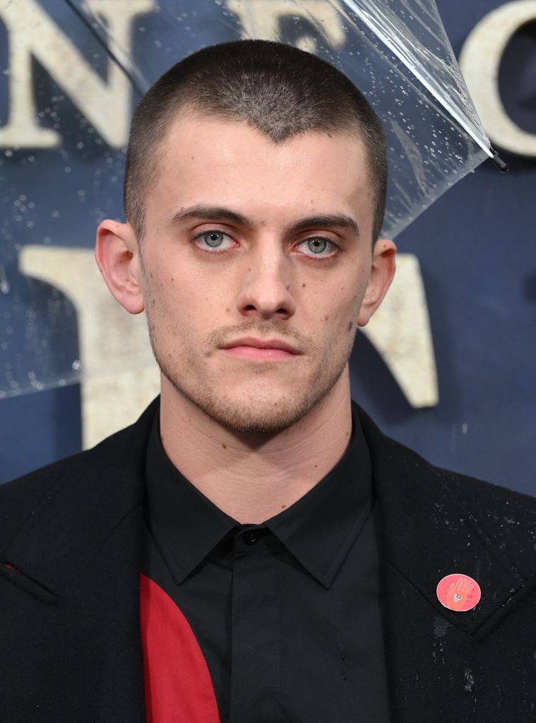 man posing at film premiere with umbrella 