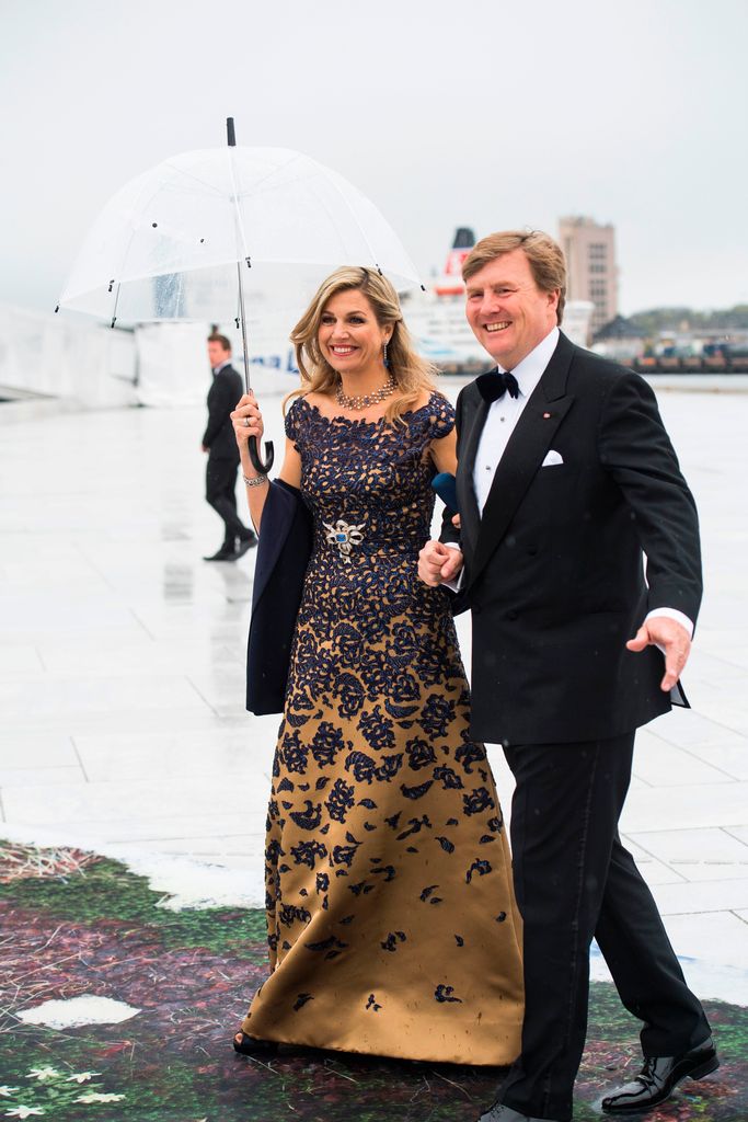 King Willem-Alexander in a tuxedo and Queen Maxima in a blue and gold dress