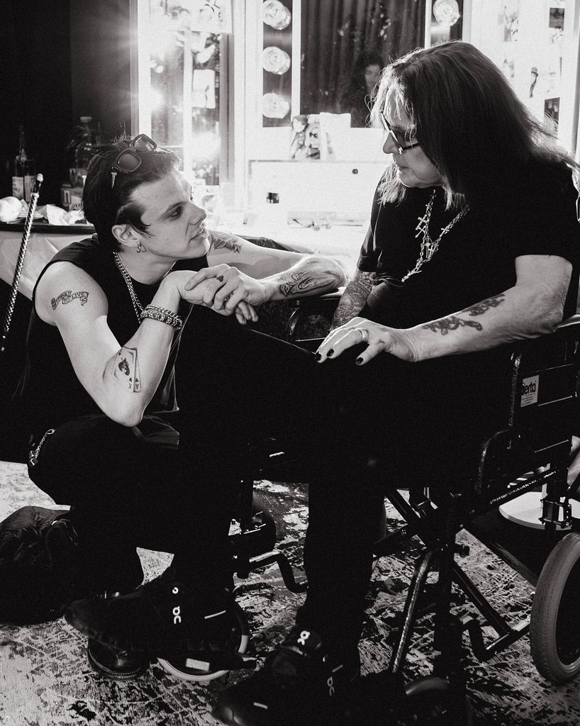 yungblud kneeling in front of ozzy osbourne in a wheelchair