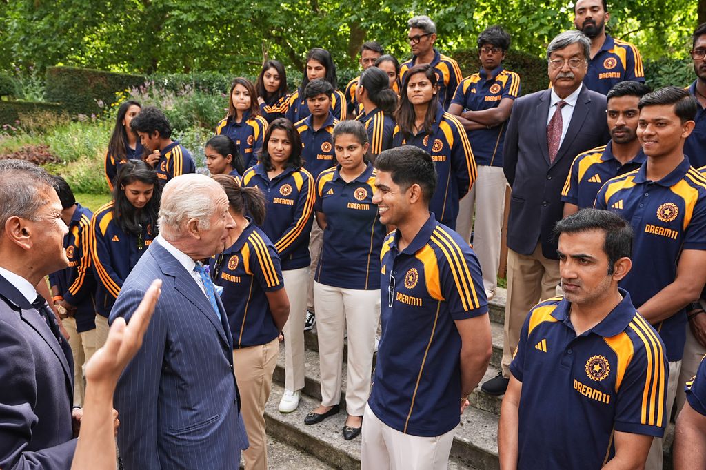 King Charles III speaks to Captain Shubman Gill as he meets members of the India men's and women's Test cricket teams during an audience in the gardens of Clarence House