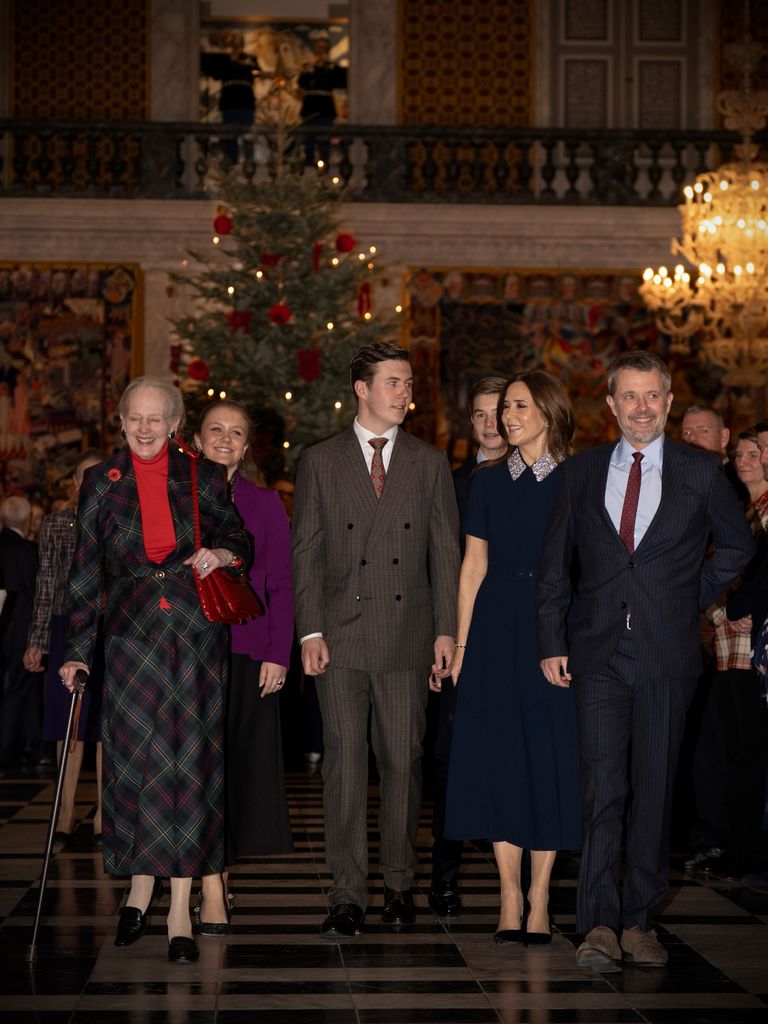 Queen Mary in dark room for party beside king frederik, queen margrethe and prince christian