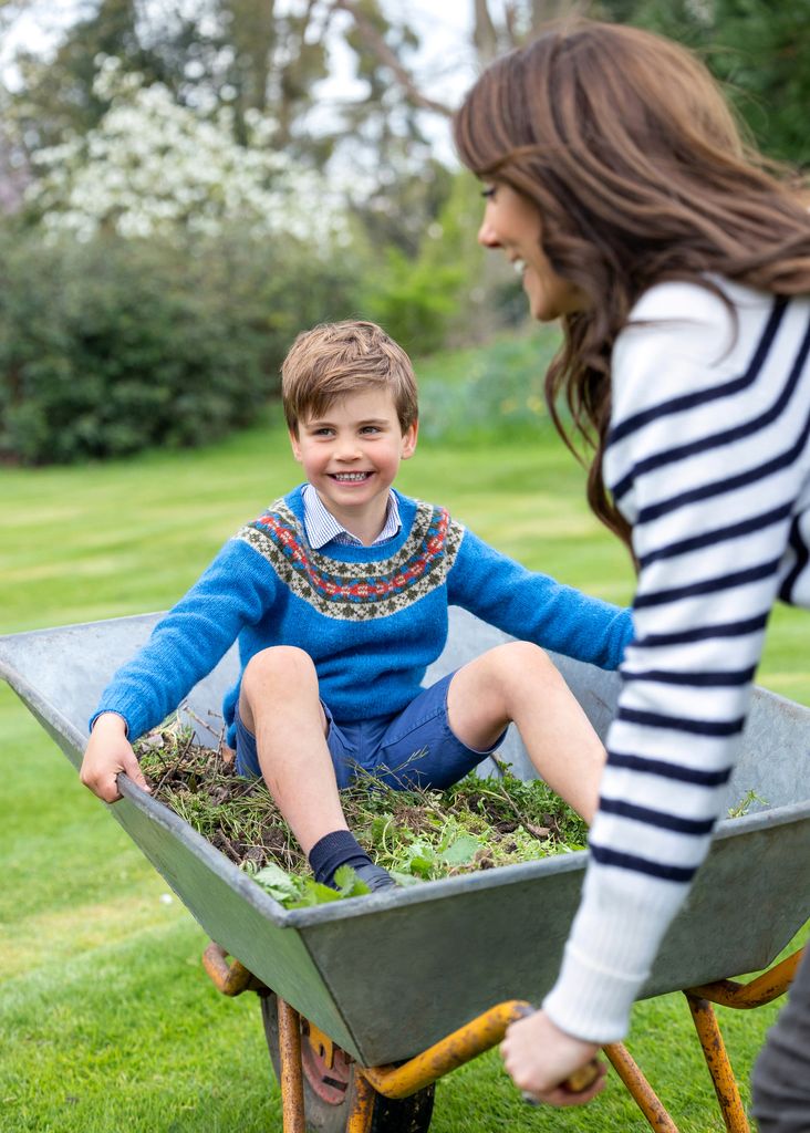 Prince Louis is pictured being pushed in a wheelbarrow by mum Kate