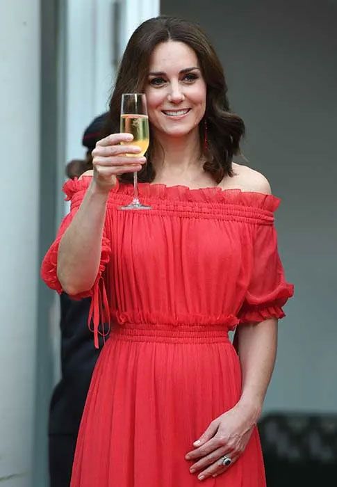 Kate Middleton holds a glass of champagne on royal tour of Poland and Germany in 2017