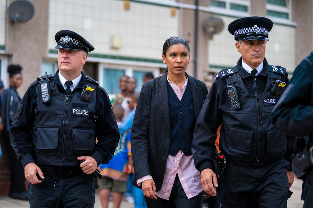 two police officers waling alongside detective