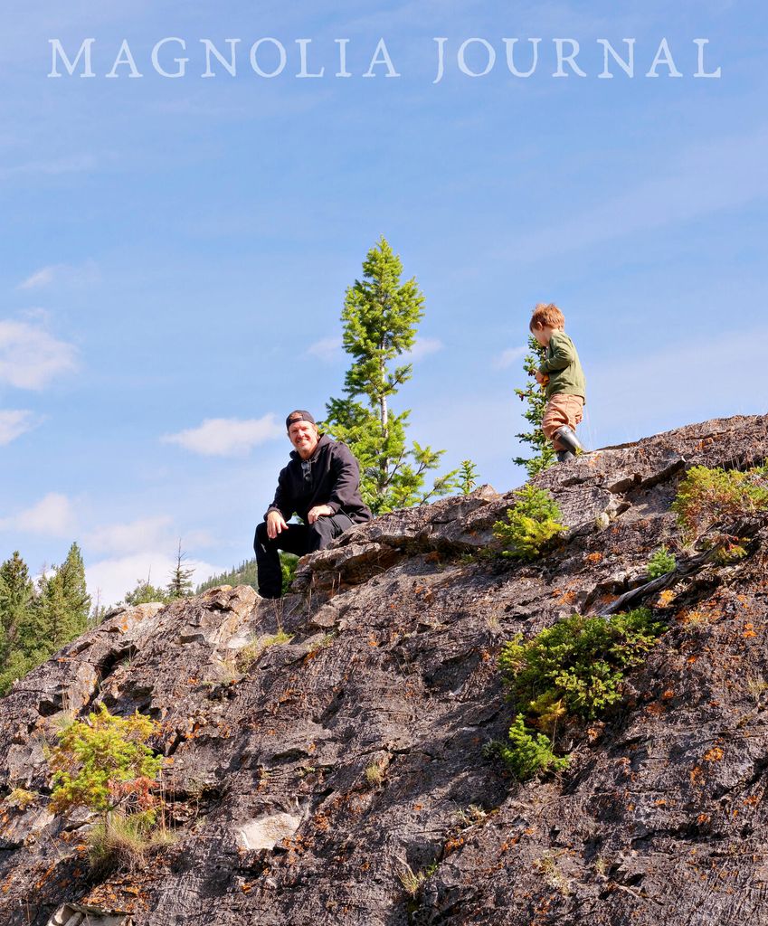Chip Gaines and son Chip sit on a rock in Banff National Park