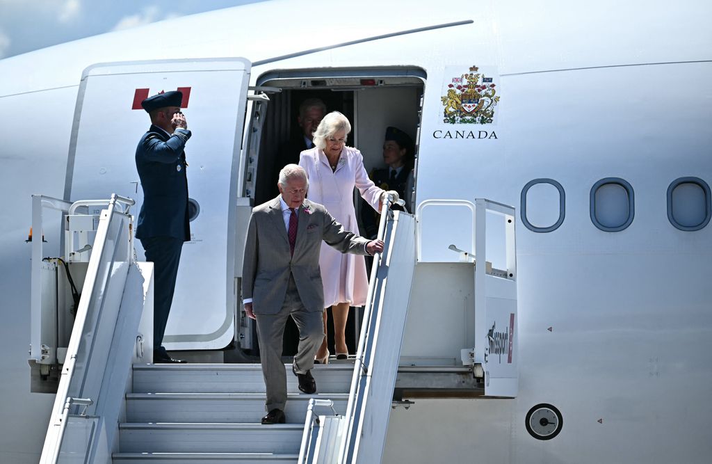 King Charles and Queen Camilla getting off of a plane