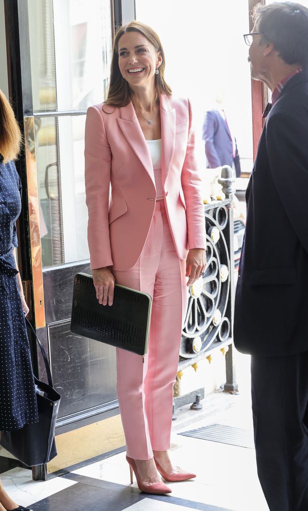 Kate Middleton, mengenakan jumpsuit merah muda, berbicara dengan Dr. Alain Gregoire setelah pertemuan meja bundar dengan pemerintah dan menteri pendidikan anak usia dini untuk menandai peluncuran penelitian baru dari Royal Foundation Centre for Early Childhood pada 16 Juni 2022 di London, Inggris.