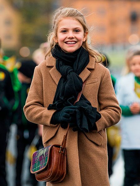 Princess Estelle of Sweden wearing a camel coat and scarf