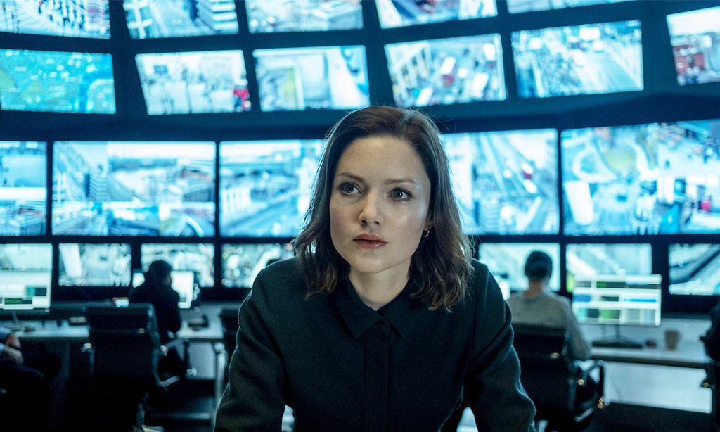 close-up of woman behind surveillance screens