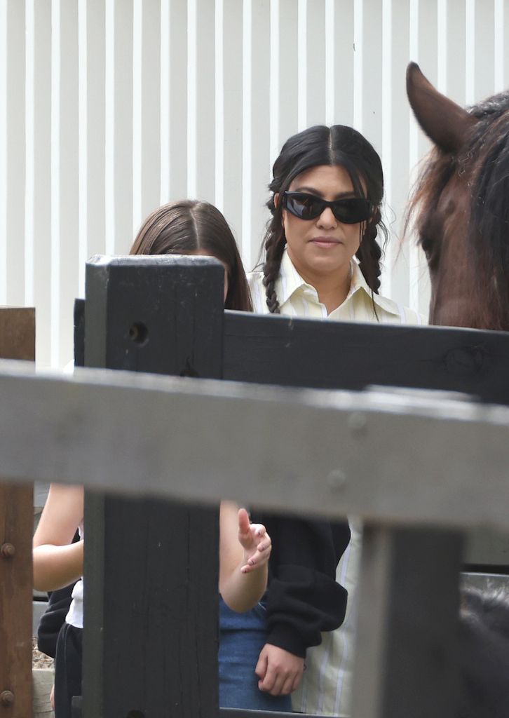Kourtney feeds horses with daughter Penelope while visiting a farm in Australia