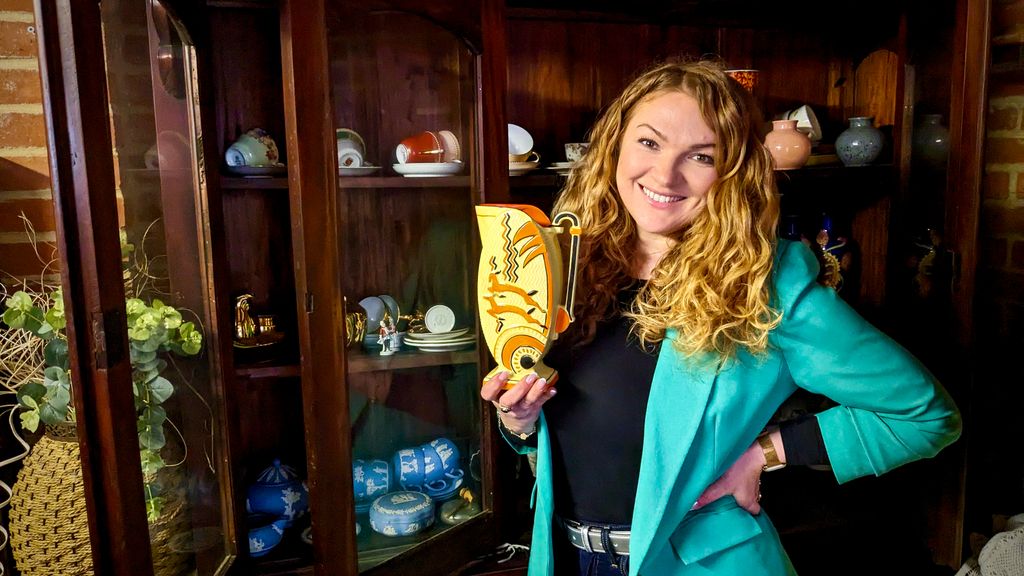 Irita holding item in front of display case on The Derbyshire Auction House 