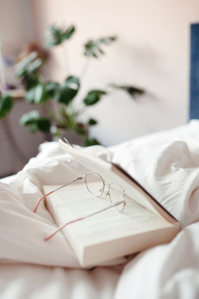Glasses resting on a book on a bed