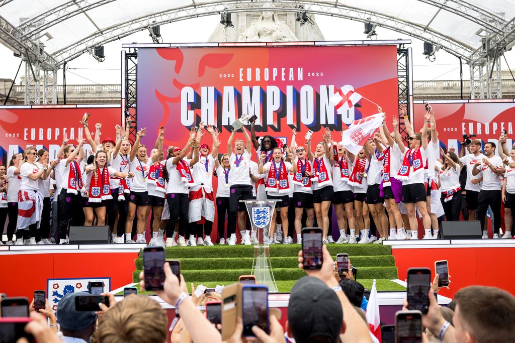 Lionesses lifting trophy in front of Buckingham Palace