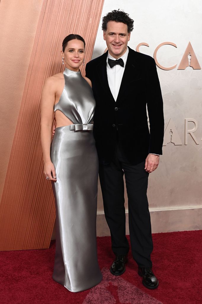 Felicity Jones and Charles Guard smile for photographers at the 97th Annual Academy Awards