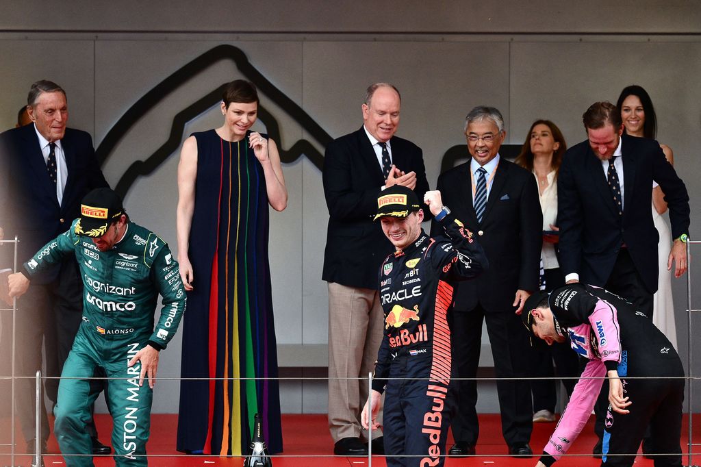 Winner Red Bull Racing's Dutch driver Max Verstappen (C), second-placed Aston Martin's Spanish driver Fernando Alonso (2nd L) and third-placed Alpine's French driver Esteban Ocon (R) arrive on the podium flanked by Princess Charlene of Monaco (3rd L) and 