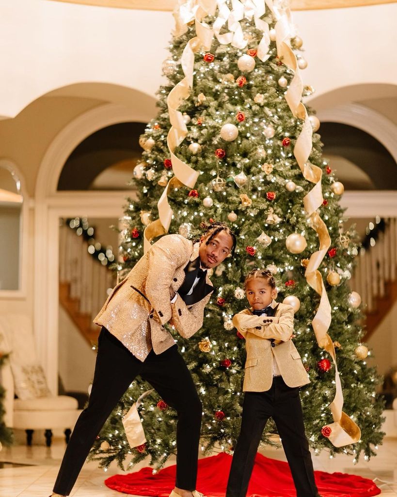 Nick Cannon and his son Golden pose in front of a Christmas tree
