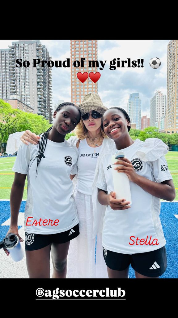 Madonna poses next to her twins at football match