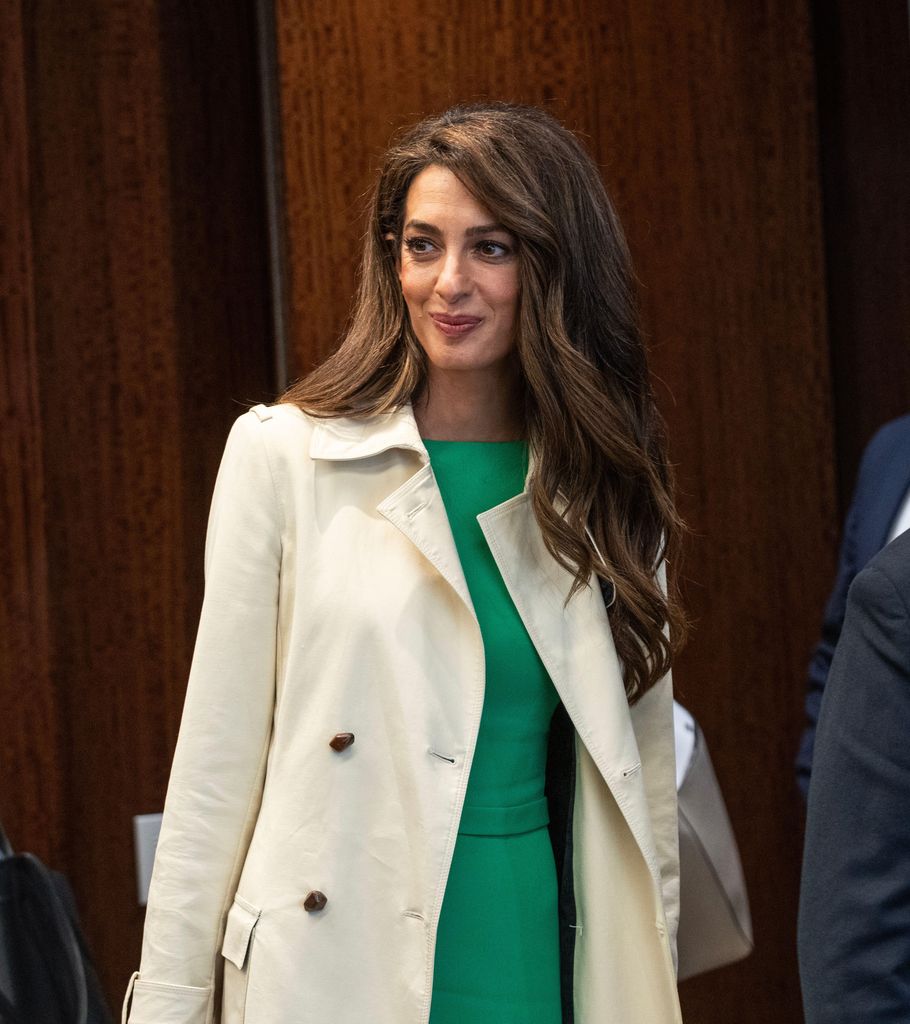 Amal Clooney wearing cream coat and green dress at UN Headquarters in New York 