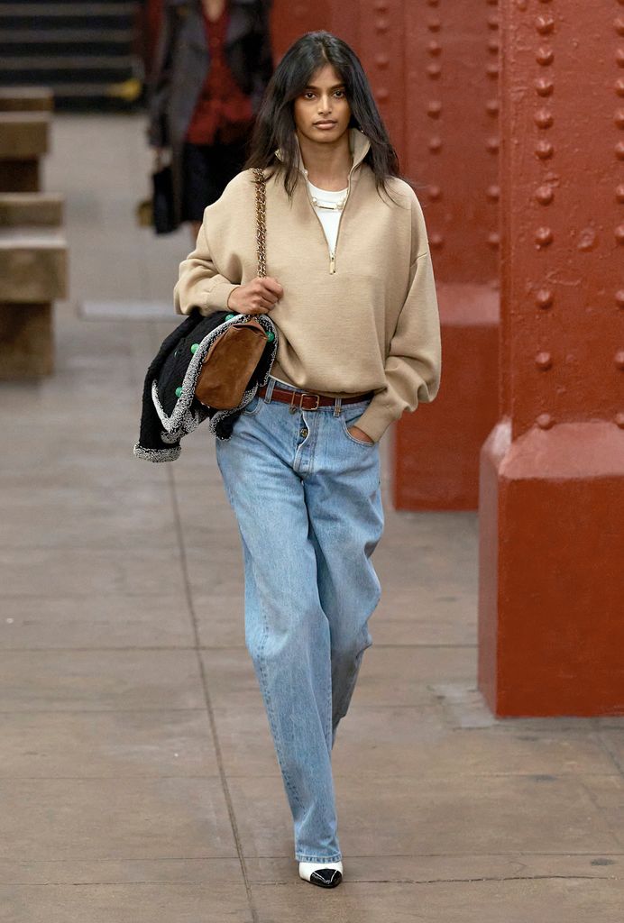 chanel model in blue jeans and beige jumper