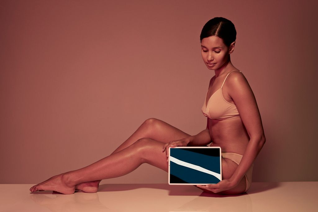 Female holding tablet in front of body to display coloured x-ray illustrations made out of hand made paper structuresFemale holding tablet in front of body to display coloured x-ray illustrations made out of hand made paper structures