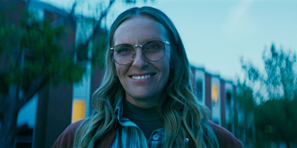 close-up image of woman with glasses smiling