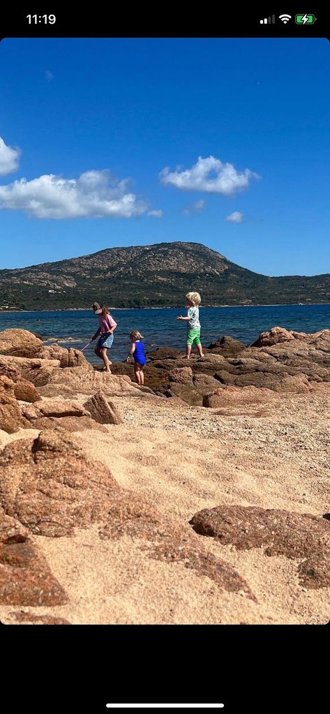 Two of the Johnson children walk along some rocks