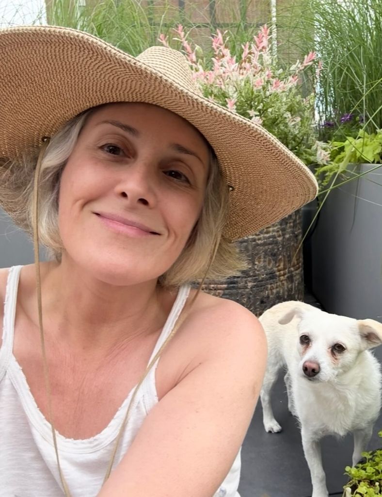 ricki lake wearing a hat and smiling in her garden
