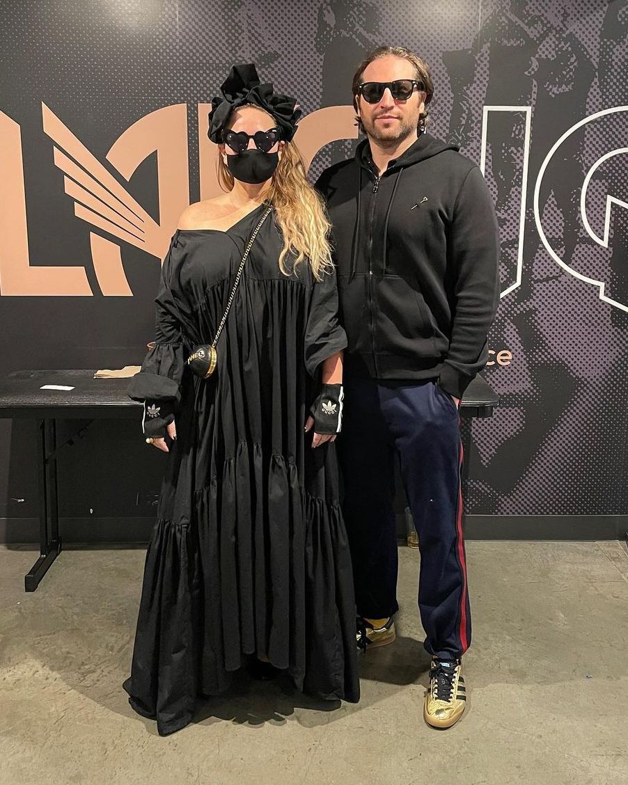 Sia in a black dress and mask with her partner