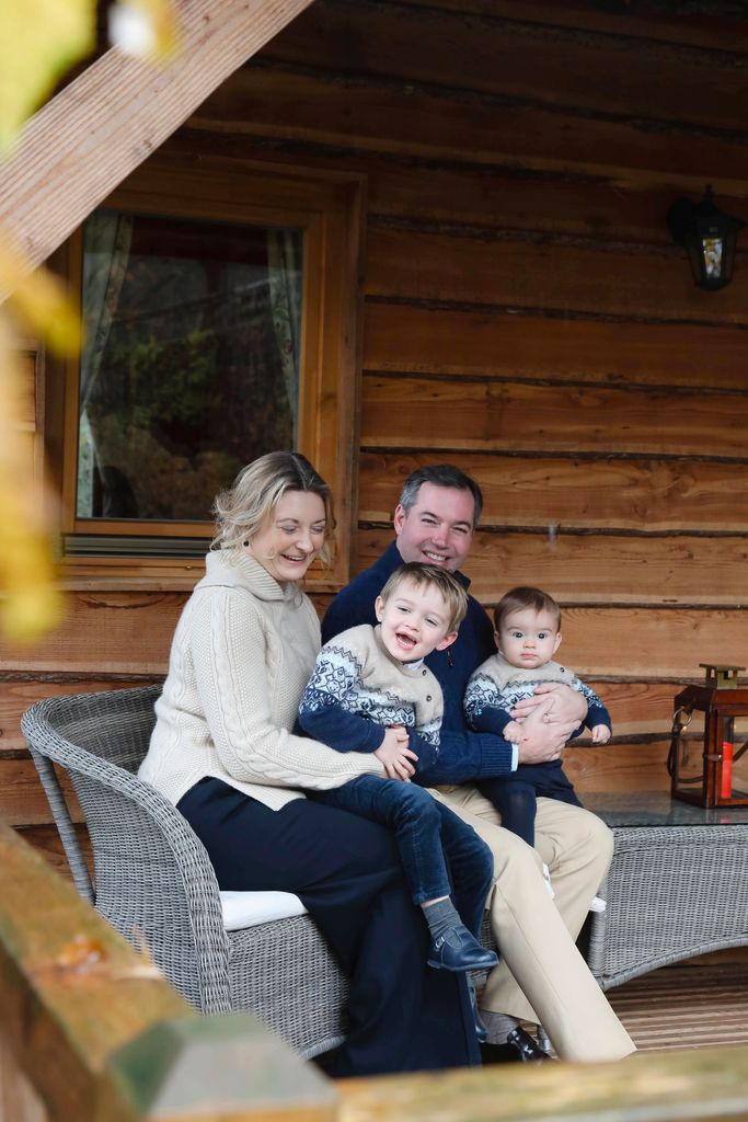 family cuddling outdoors in a wood cabin 