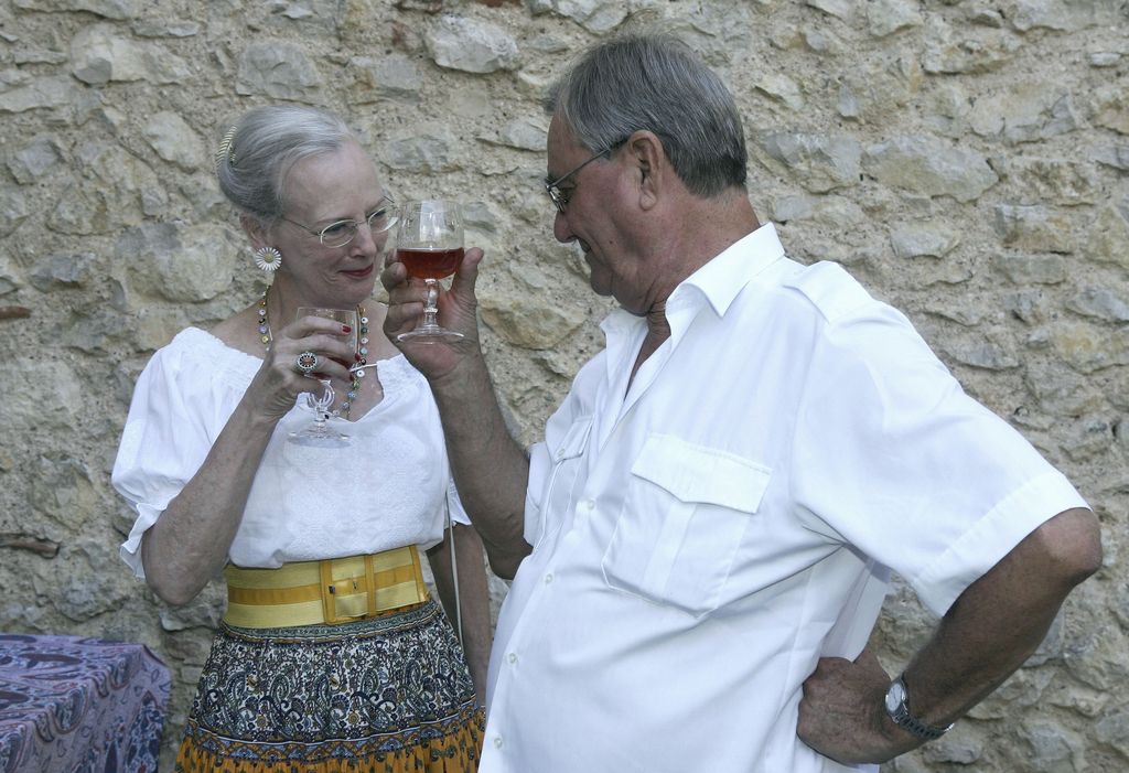 Prince Henrik of Denmark makes a toast with Queen Margrethe II of Denmark during the annual photocall in their summer residence