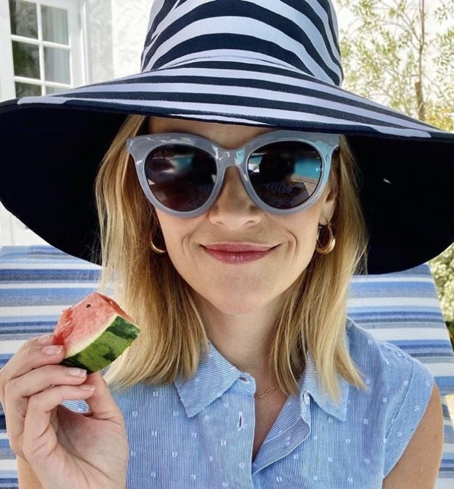 Reese Witherspoon smiling and eating watermelon 