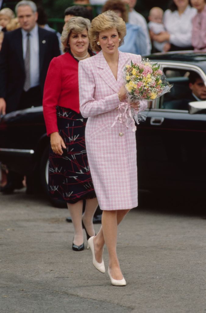 Princess of Wales in a checked coatdress holding flowers