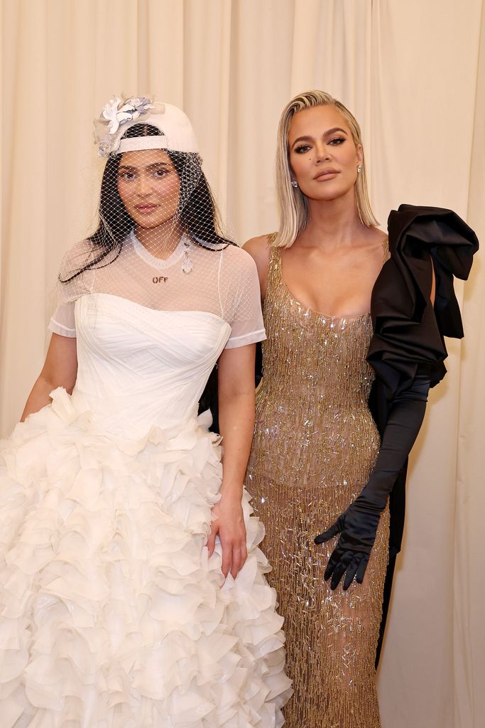 Khloe and Kylie smiling on a red carpet