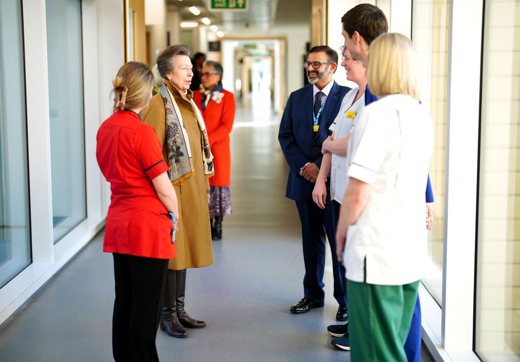 Princess Anne speaks to staff in hospital corridor