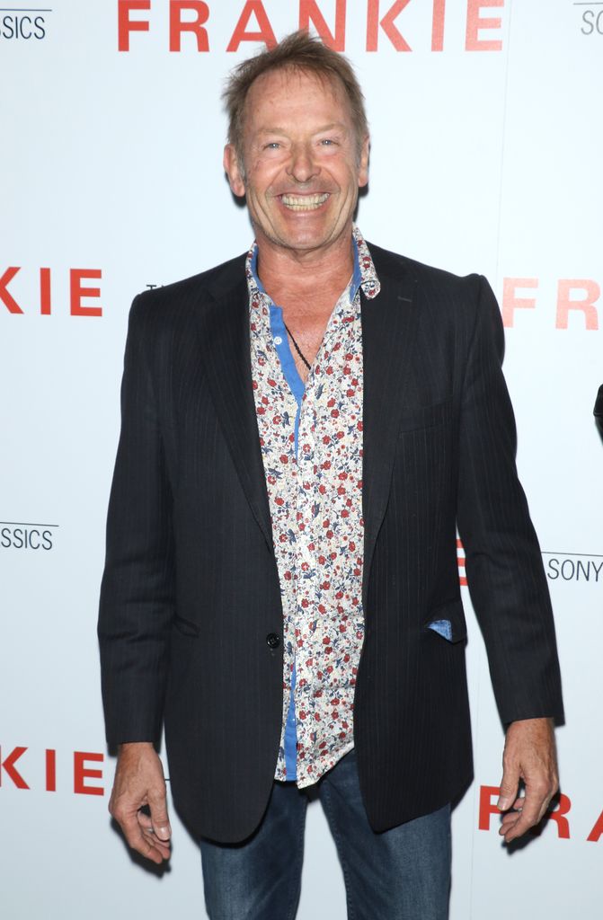 Simon Kirke in blazer and floral shirt