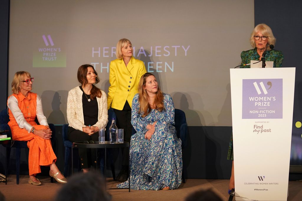 Four women watching Queen Camilla deliver a speech